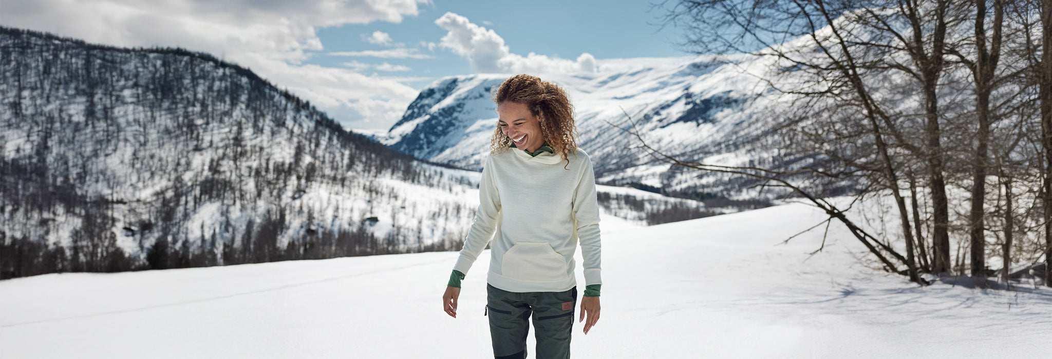 Jente på snøfjell med Janus Classic hettegenser i farge hvit